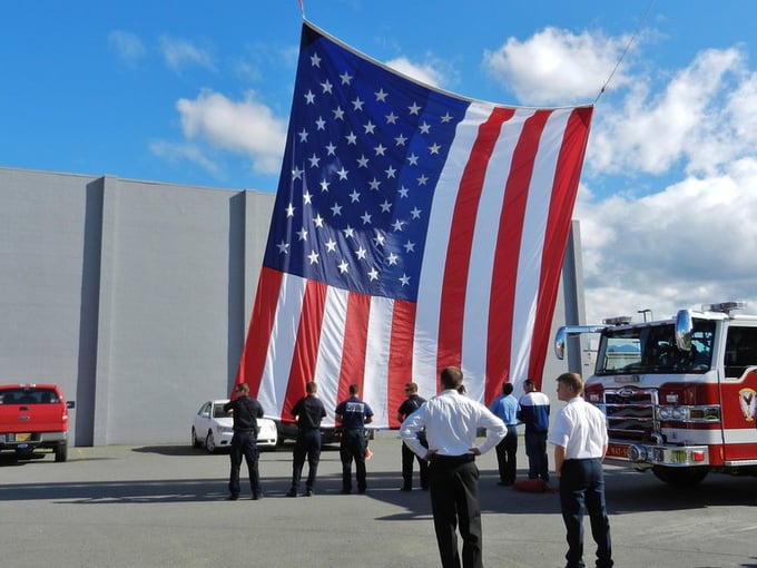 Firefighters watching a flag being lowered for retirement