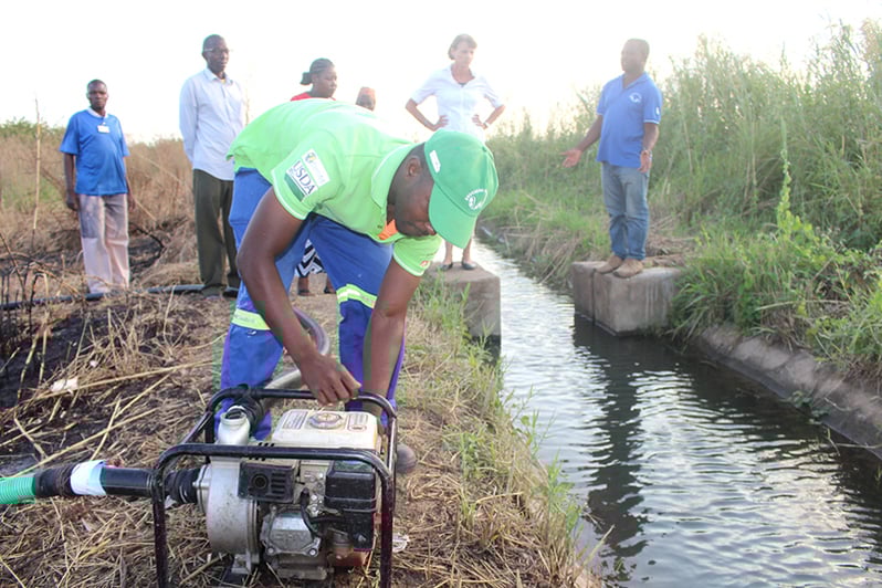 A farmer services the irrigation equipment for the Home Grown Garden.